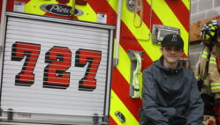 Christian Teeter, a 14-year-old eighth grade student at Edward Stone Middle School, sits on the back of Engine 727 April 26 at the Burlington Fire Department just before leaving on a call.